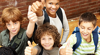 Group of elementary school students showing a thumbs up sign